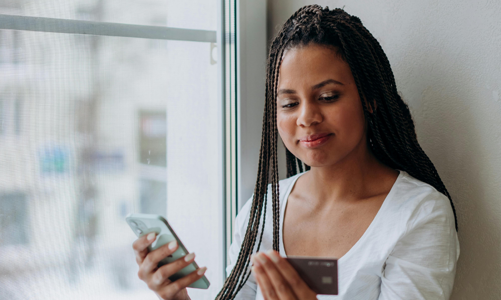 mujer revisando su scoring bancario con su tarjeta de credito