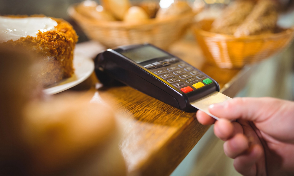 Mano insertando una tarjeta en un datáfono, proceso de pago que puede mostrar el error causa 116.