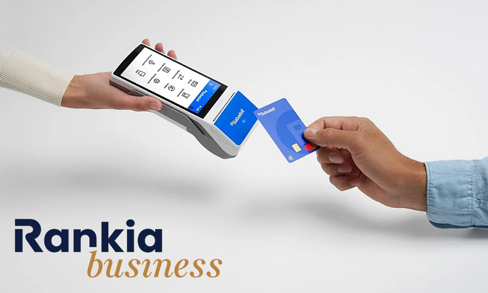 Mano sosteniendo un datáfono Sabadell mientras un cliente paga con tarjeta, representando el funcionamiento del TPV Sabadell para autónomos y empresas.