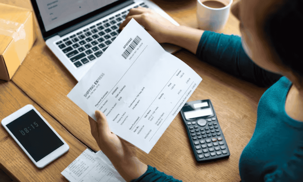 Persona revisando facturas y calculadora para hacer un arqueo de caja