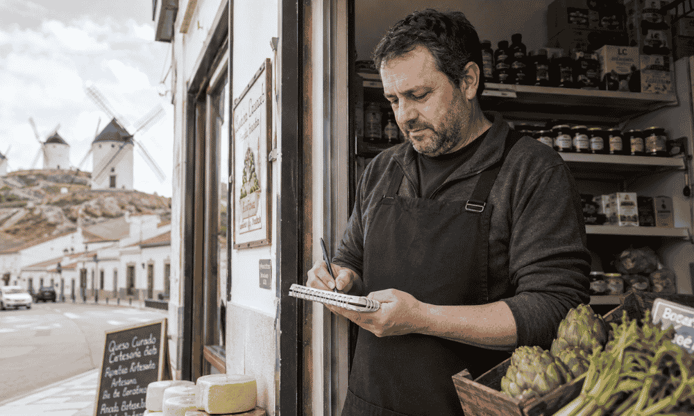 Comerciante autónomo en Castilla-La Mancha tomando notas frente a su tienda