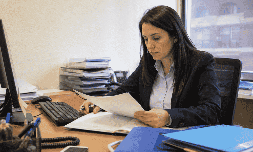 Empleada de oficina revisando documentos del grupo de cotización 7