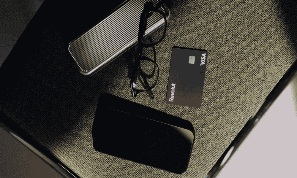Tarjeta Revolut Business junto a smartphone y accesorios de trabajo sobre escritorio