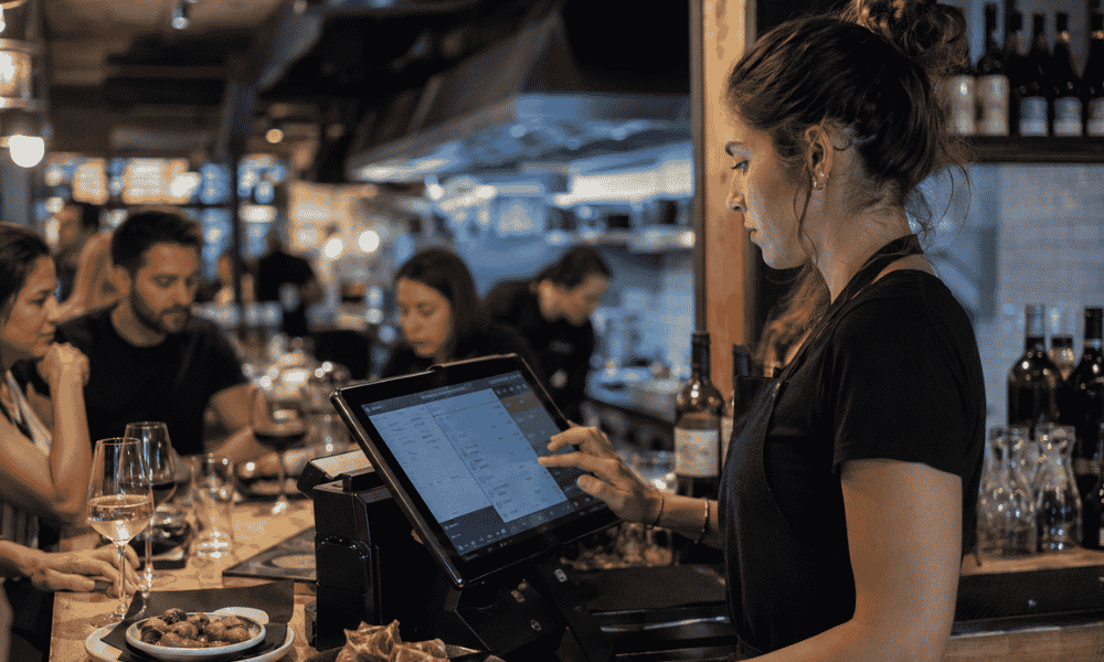Camarera utilizando un TPV táctil en un restaurante