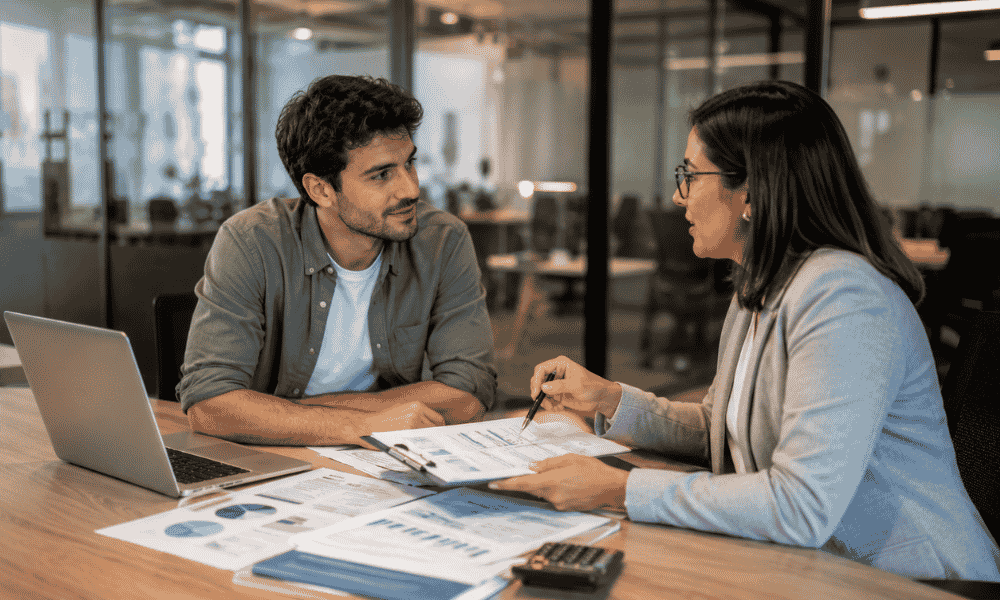 Emprendedor reuniéndose con una asesora para solicitar un préstamo para abrir una empresa sin aval.