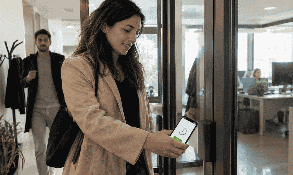 Empleada realizando el fichaje digital con el móvil al entrar en la empresa
